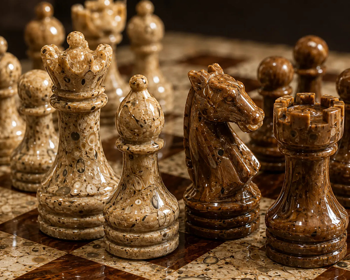 A close-up of polished stone chess pieces on a marble chessboard, including a crown, knight, rook, and pawns in warm beige and brown tones.
