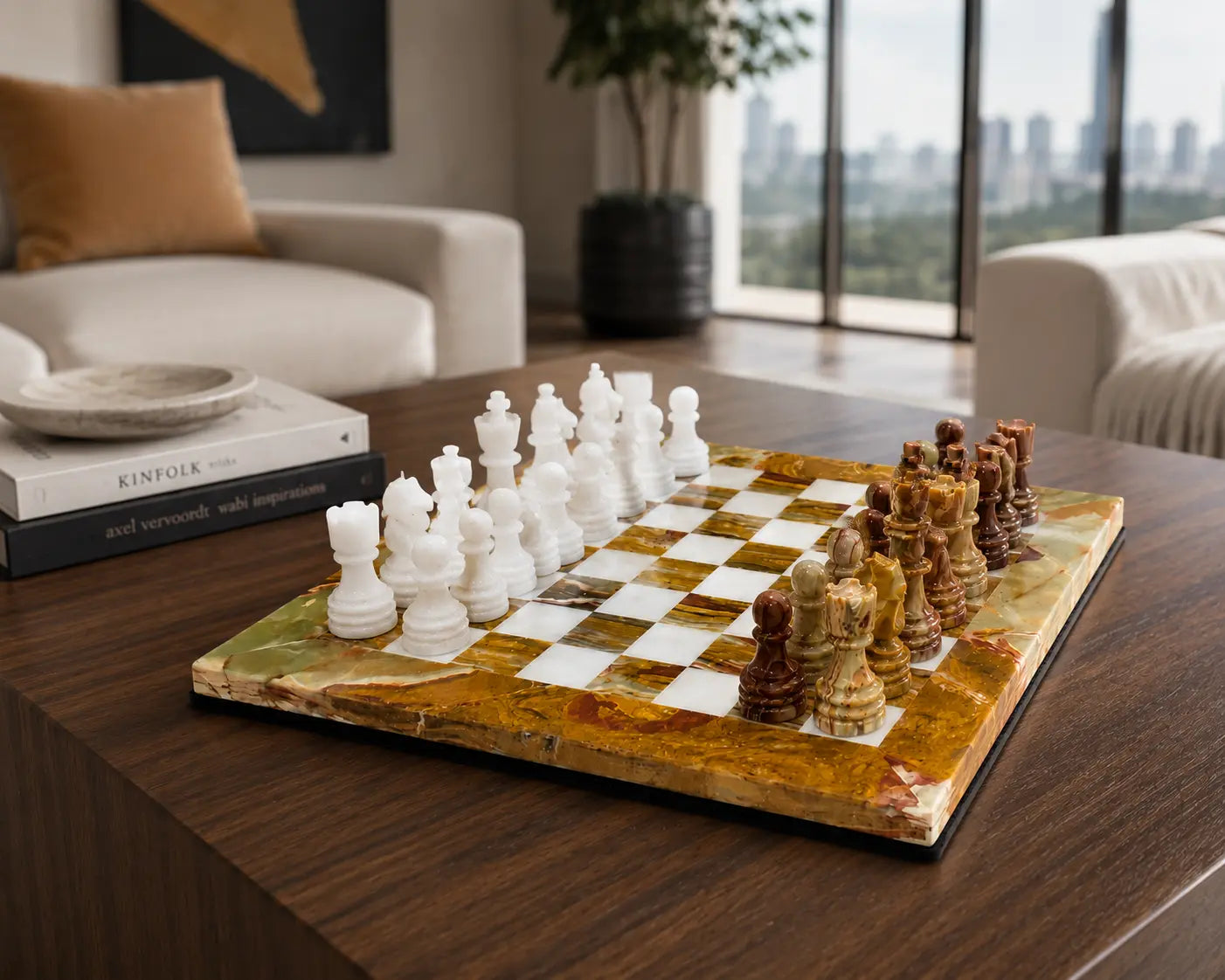 A polished stone chess set on a live-edge marble board, displayed on a dark wood coffee table in a modern living room setting.