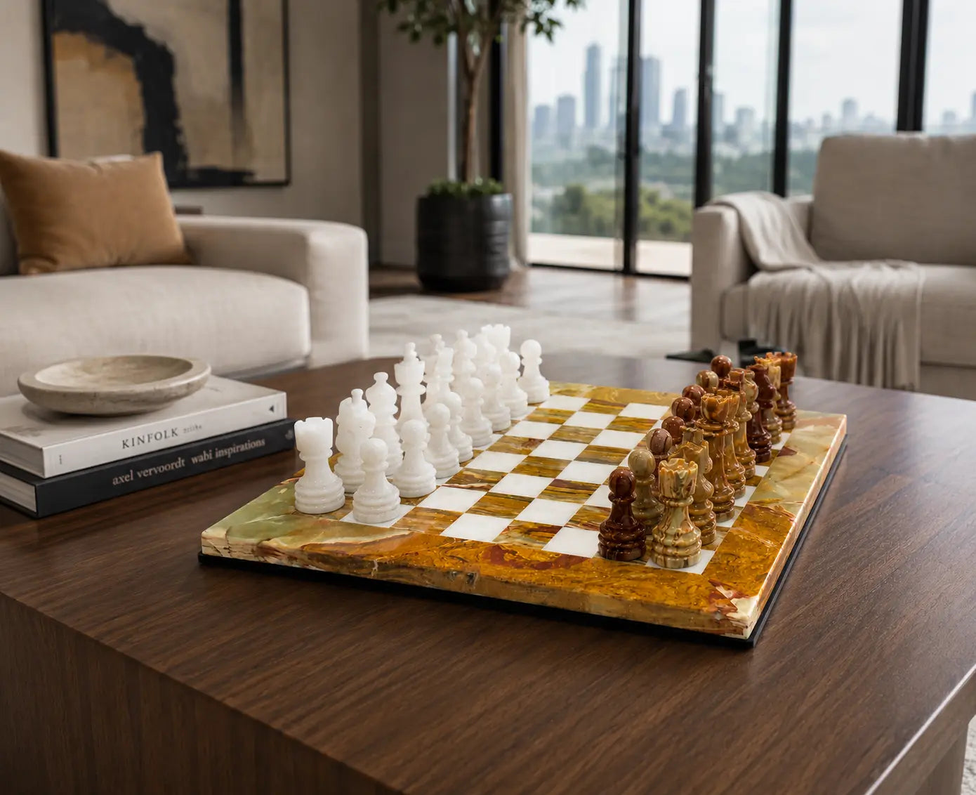 A marble chessboard with white and brown chess pieces set on a dark wood coffee table in a modern living room.