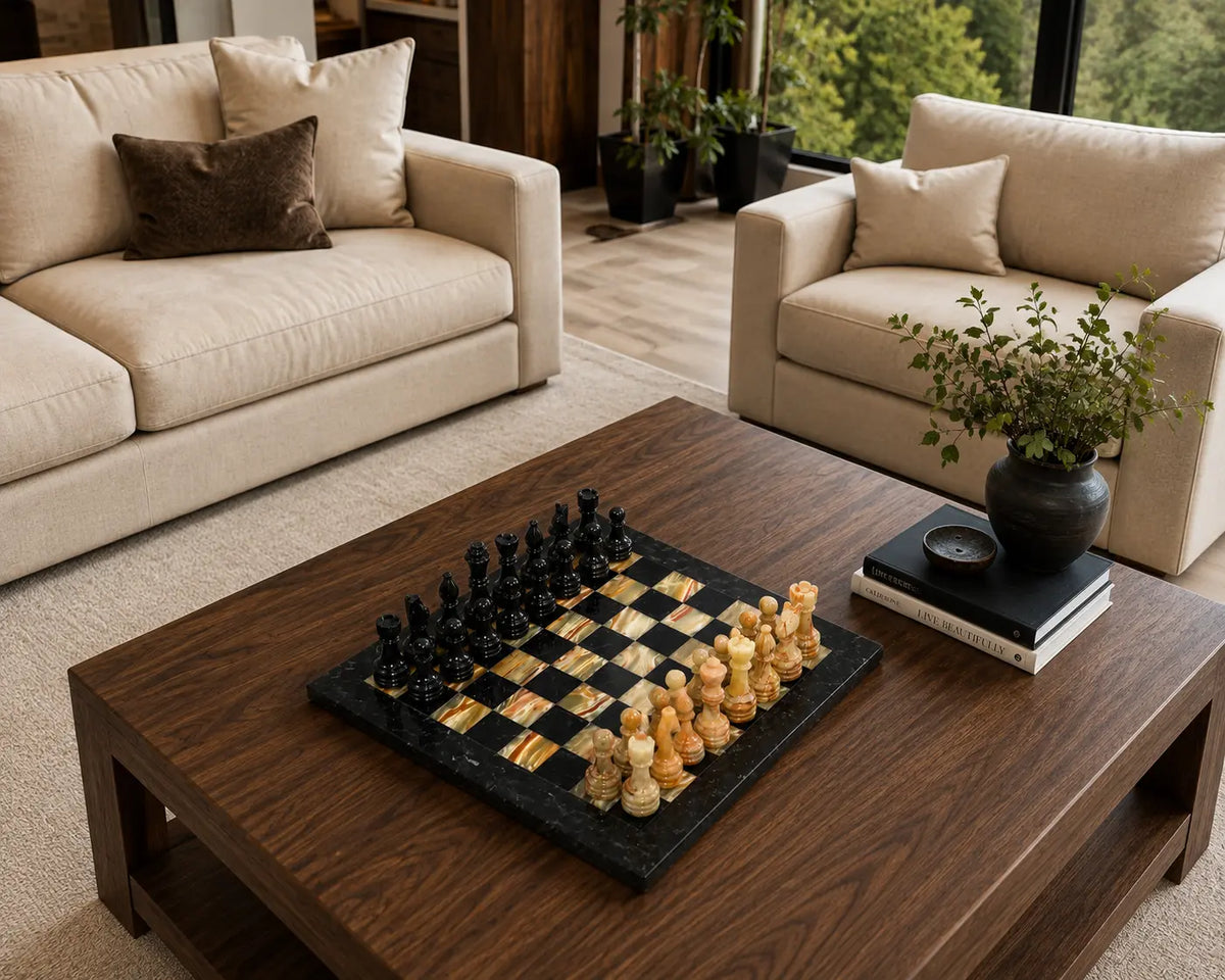 A luxury chess set with black and gold checkers and ivory pawns displayed on a dark wood coffee table in a modern living room setting.