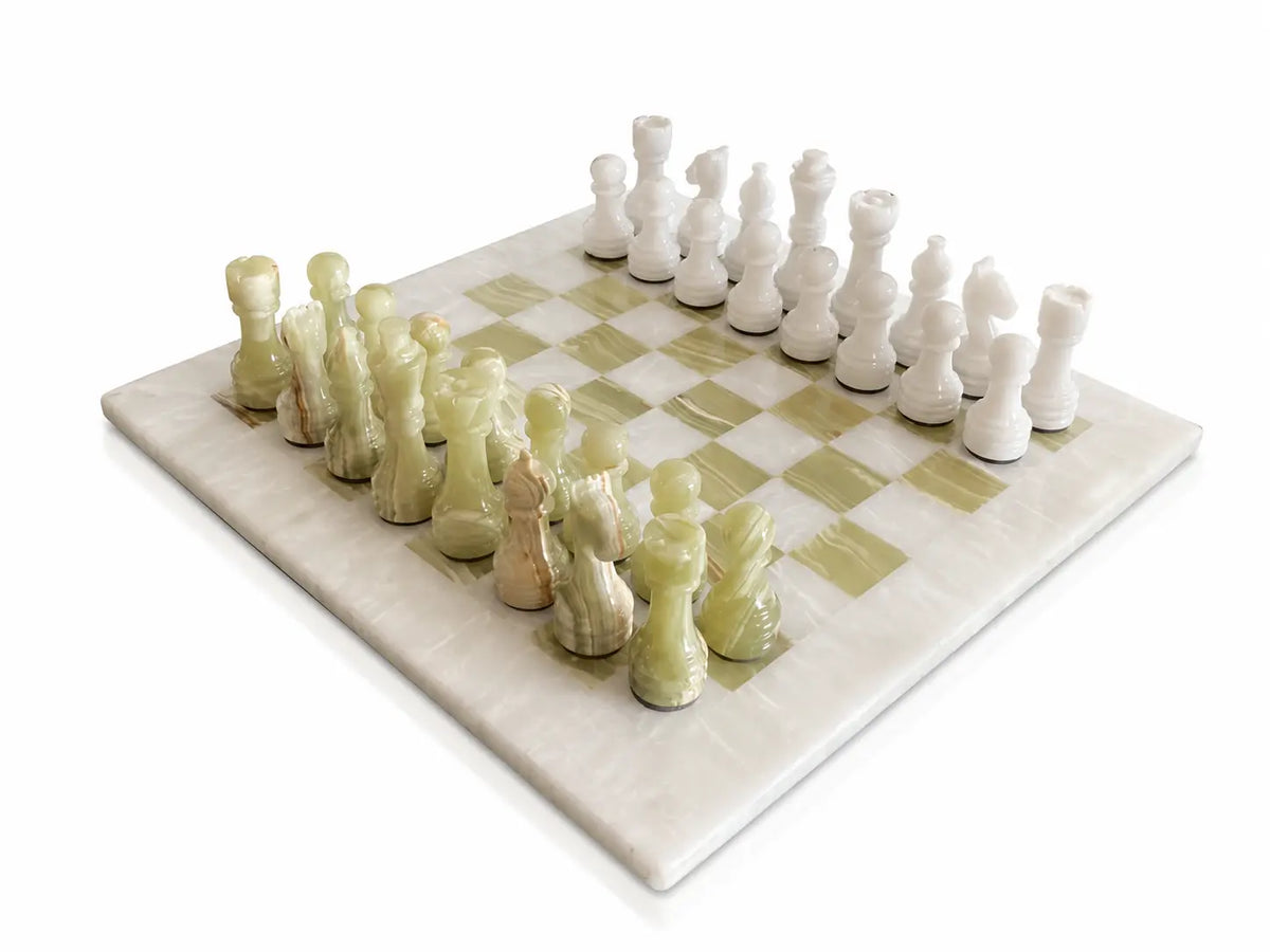 A marble chess set with a cream and pale green checkered board and sculptural chess pieces, photographed on a clean white background.