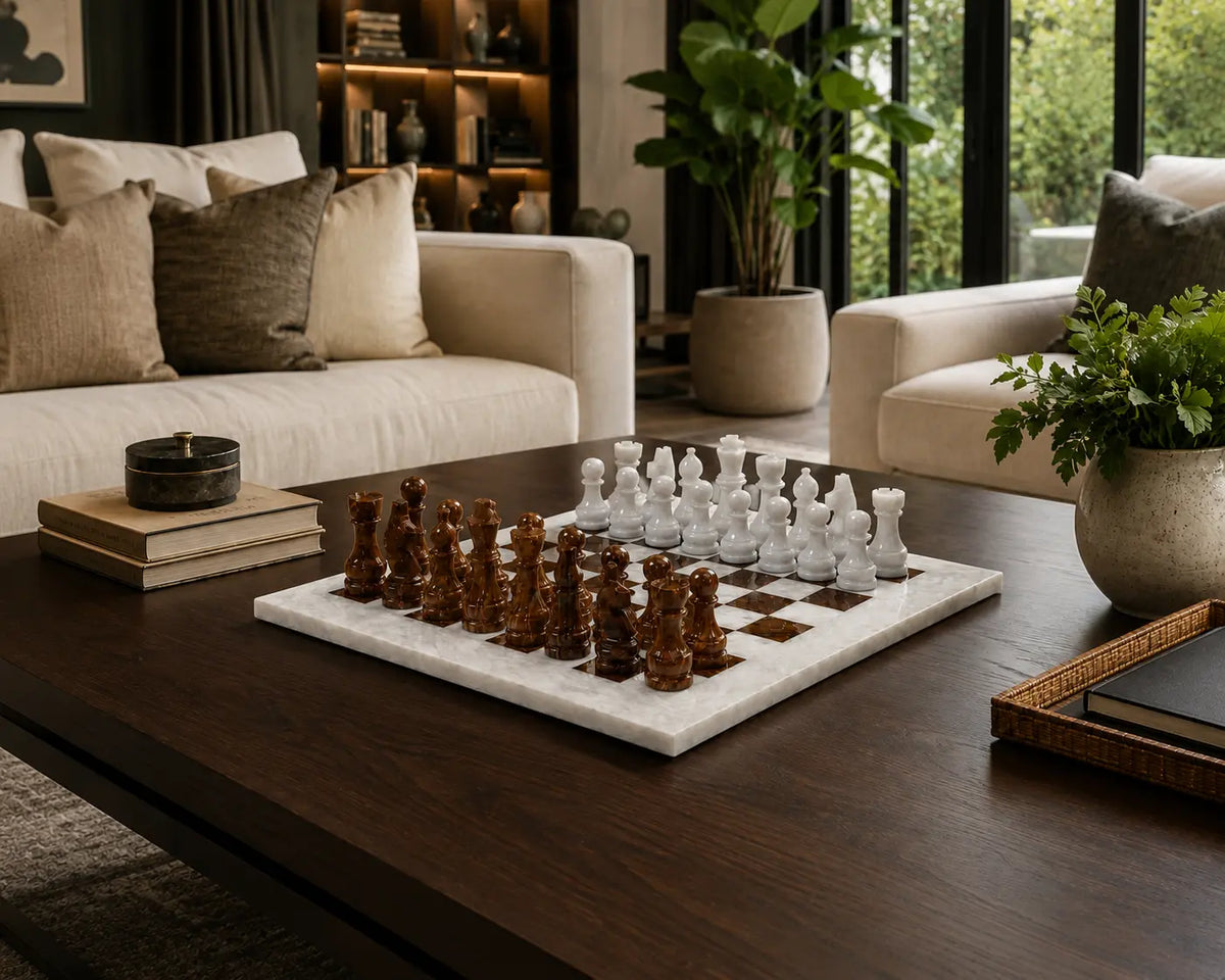 A marble chessboard with carved wooden chess pieces in a modern living room setting on a dark wood coffee table.