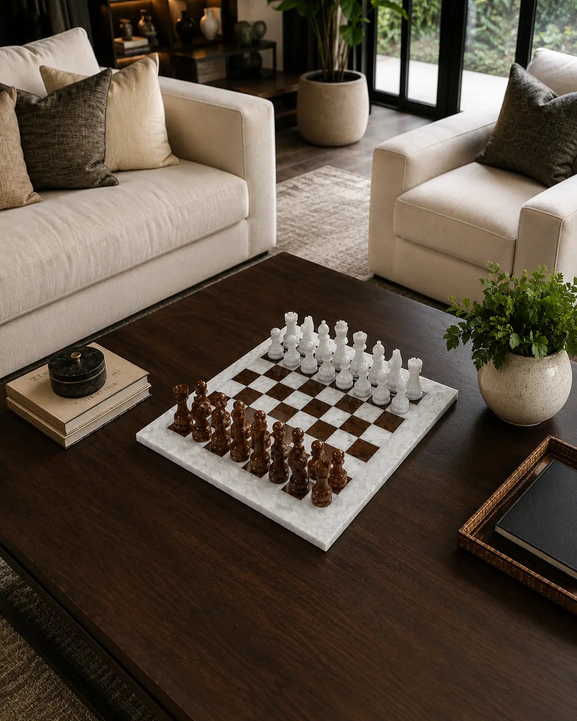 A marble chessboard with white and dark wood chess pieces arranged on a dark wood coffee table in a modern living room setting.
